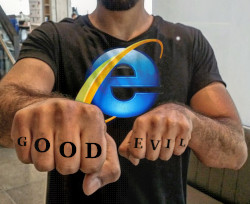 Two fists with the words 'good' and 'evil' tattooed on the fingers.  The owner of the fists is wearing an Internet Explorer shirt and has his face out of camera to protect his identity.